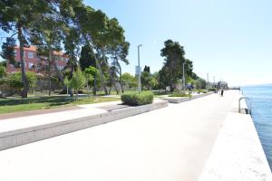 a sidewalk next to a body of water at Apartment Nikki Kolovare Beach in Zadar