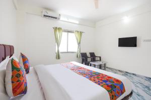 a white bedroom with a bed and a window at FabHotel Infinity Residency in Pune +26 photos