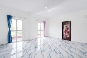 an empty room with white walls and windows at FabHotel Infinity Residency in Pune