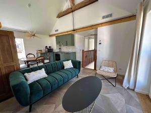 a living room with a green couch and a table at Duplex des montains in Loches