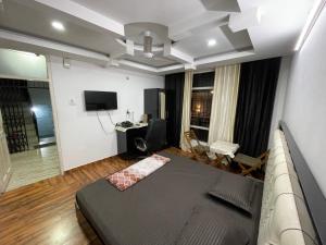 a bedroom with a bed and a couch in a room at Tatva stays in Dharmsāla