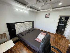 a bedroom with a bed and a chair in it at Tatva stays in Dharmsāla