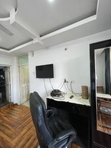 a room with a desk and a chair and a television at Tatva stays in Dharmsāla +21 photos