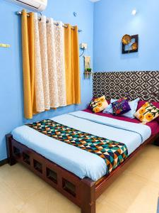 a bed in a room with blue walls and curtains at BlueWaves in Pondicherry