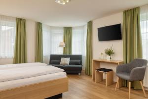 a hotel room with a bed and a couch at OXA - Easy Escape - Bed & Breakfast in Hittisau +33 photos