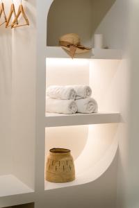 a room with white shelves with towels and a basket at Olea White in Skiathos +37 photos
