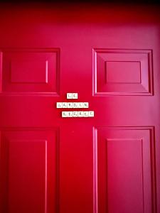 a red door with a sign on it at Le jardin secret in Reims