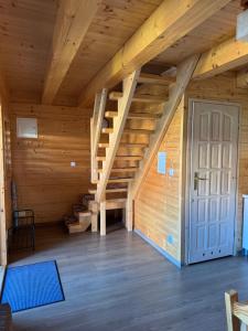 an attic room with stairs and a door at Domki Prima Baltic in Sarbinowo