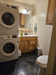 a bathroom with a washing machine and a toilet at River View Upstairs Apartment in Kenai +11 photos
