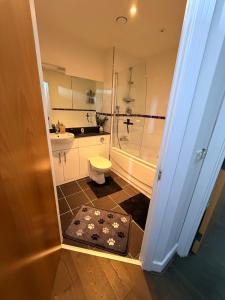 a bathroom with a shower and a toilet and a sink at Cozy One bedroom with Free Underground parking in Mailbox Birmingham city in Birmingham +54 photos