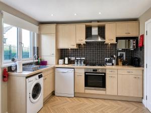 a kitchen with a washing machine and a washer at Tigh na Lochan in Aviemore
