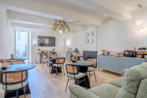 a living room with tables and chairs and a kitchen at B&B Le Suite del Corso in Lugo
