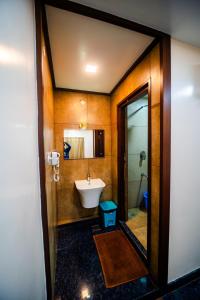 a bathroom with a sink and a toilet and a mirror at V V Residency in Thanjāvūr