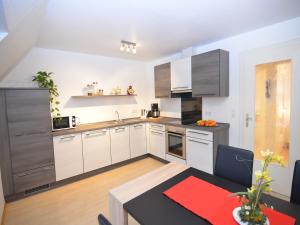 a kitchen with white cabinets and a dining table at Apartment near ski area in Wehrstapel in Sauerland in Meschede