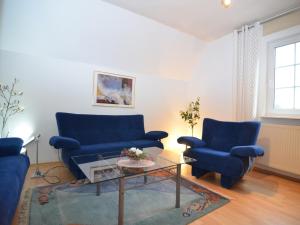 a living room with two blue chairs and a table at Apartment near ski area in Wehrstapel in Sauerland in Meschede