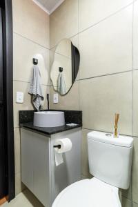 a bathroom with a white toilet and a mirror at Studio c AC, Piscina e Café Novo Hamburgo in Novo Hamburgo +19 photos