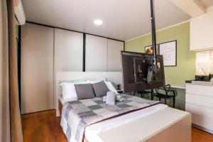 a bedroom with a large white bed in a room at Studio c AC, Piscina e Café Novo Hamburgo in Novo Hamburgo
