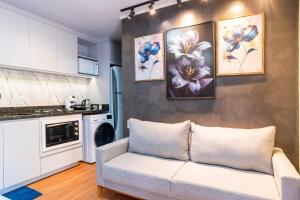 a living room with a couch and a kitchen at Studio c AC, Piscina e Café Novo Hamburgo in Novo Hamburgo