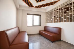 a waiting room with a couch and a window at FabHotel Kalptaru in Pune +32 photos