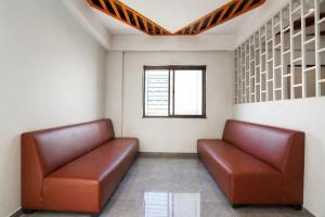 a waiting room with two brown leather seats at FabHotel Kalptaru in Pune