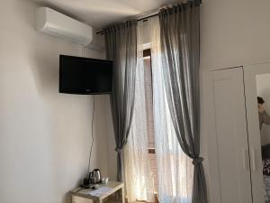 a room with a window with a flat screen tv at Novara Il Gallo in Lumellogno