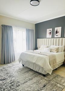 a bedroom with a large bed and a large window at Sweet Daisies Apartment in Mbabane
