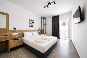 a hotel room with a bed and a television at Salty Sea View Apartments in Polychrono