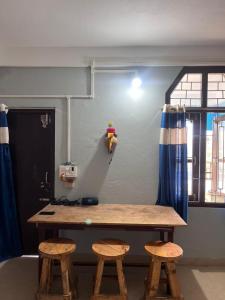 a room with a table and two stools at Tani Adventure in Ziro