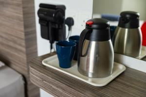 a coffee pot and cups sitting on a shelf at Parkland Hotel in Brinchang