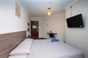 a bedroom with two beds and a flat screen tv at Parkland Hotel in Brinchang