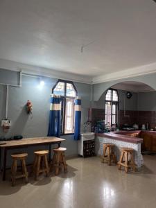 a kitchen with a table and stools in a room at Tani Adventure in Ziro