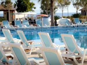 a group of chairs sitting next to a swimming pool at Grecia's Dhermi in Dhërmi