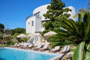 a villa with a swimming pool and lounge chairs at Casa Redonda by Villas Aura - Retreat 2 in Aroeira