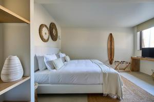 a white bedroom with a bed and a television at Casa Redonda by Villas Aura - Retreat 2 in Aroeira