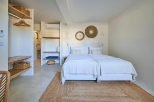 a white bedroom with a white bed and a rug at Casa Redonda by Villas Aura - Retreat 2 in Aroeira +27 photos