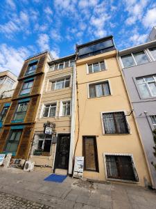 a yellow building with a sign in front of it at Marmara Guesthouse in Istanbul