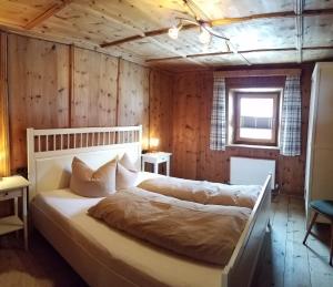a bedroom with a bed in a room with wooden walls at Alpin Appart Reiter- & Alpakahof in Niederthai in Niederthai
