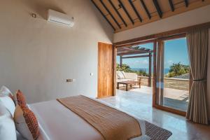 a bedroom with a bed and a view of the ocean at Salty Lotus in Uluwatu +86 photos