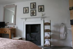 a bedroom with a fireplace and a mirror and a bed at Coxwold Tearoom in Coxwold