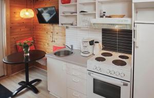 a small kitchen with a stove and a table at Beautiful Apartment In Farsø in Farsø
