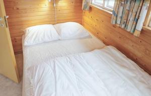 a bedroom with a bed with white sheets and pillows at Beautiful Apartment In Farsø in Farsø