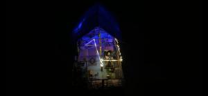 a building with a blue light in the dark at The Last Stop Backpackers Hostel in Auroville
