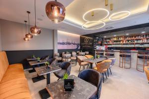 a restaurant with tables and chairs and a bar at Aurelia Residence in Metković