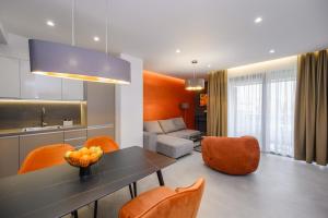 a living room with a table and orange chairs at Aurelia Residence in Metković
