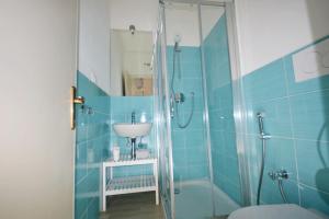 a blue tiled bathroom with a sink and a shower at Casavacanze Zeus in Marciana Marina +67 photos