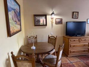 a dining room with a table and a flat screen tv at Guest House Danver in Yaremche