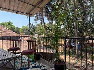 a patio with two chairs and a table and trees at TriboRoots Hostel in Anjuna +32 photos