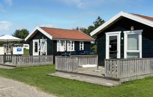 a house with a wooden fence in front of it at Cozy Apartment In Farsø With Heated Swimming Pool in Farsø