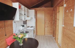 a kitchen with a table with a vase of flowers on it at Cozy Apartment In Farsø With Heated Swimming Pool in Farsø