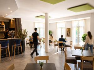 a group of people sitting at tables in a restaurant at Hotel Vela in Nago-Torbole +43 photos